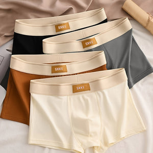 Vier Boxershorts in Schwarz, Grau, Braun und Creme, flach liegend arrangiert | Fashion Peak