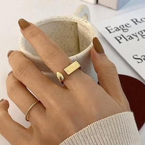 Goldene Ringe am Finger, geometrisch und schlicht, mit Kaffeetasse | Fashion Peak