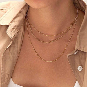 Dreilagige goldene Halskette, dünne Ketten, getragen von Frau mit Bluse | Fashion Peak