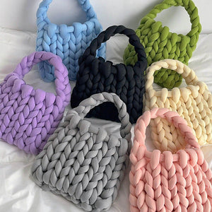Sieben grobgestrickte Handtaschen in verschiedenen Farben liegen flach nebeneinander | Fashion Peak