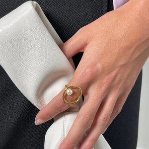 Goldener Ring mit Perle, getragen an der Hand einer Frau | Fashion Peak