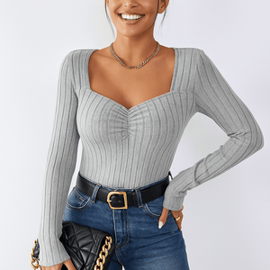 Graues geripptes Top mit quadratischem Ausschnitt getragen von lächelnder Frau | Fashion Peak