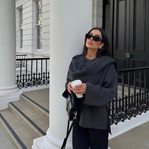 Frau trägt dunkelgrauen Cape Poncho aus Wolle mit Kaffeebecher | Fashion Peak