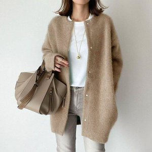 Beige gestrickte Oversized-Strickjacke mit Knöpfen, getragen von einer Frau | Fashion Peak
