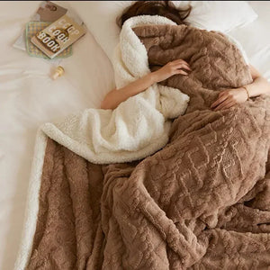 Braune Sherpa-Decke mit weißem Rand, Person liegt zugedeckt im Bett | Fashion Peak