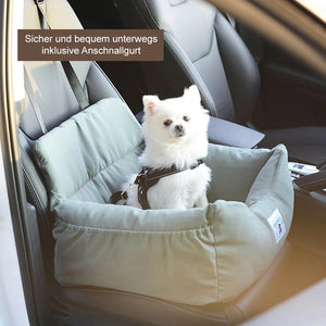 Grüner gepolsterter Hundeautositz im Auto mit weißem Hund angeschnallt | Fashion Peak
