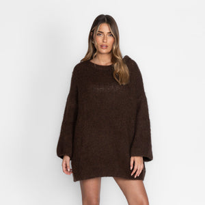 Braunes oversized Strickkleid mit weiten Ärmeln, getragen von einer Frau | Fashion Peak