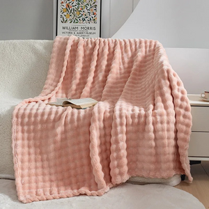 Rosa Plüschdecke mit Waffelmuster, drapiert über Sofa, mit Buch | Fashion Peak