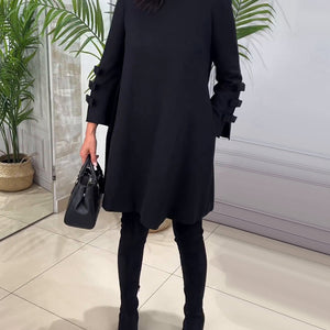 Schwarzes lockeres Kleid mit Rüschenärmeln, getragen von einer Frau mit Handtasche | Fashion Peak