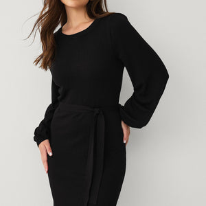 Schwarzes Strickkleid mit Gürtel, langärmelig, von lächelnder Frau getragen | Fashion Peak