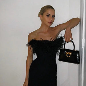 Frau trägt schwarzes Bodycon-Minikleid mit Federbesatz und schwarzer Handtasche | Fashion Peak