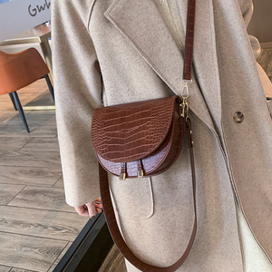 Braune Sattel-Umhängetasche mit Krokoprägung, getragen über beigem Mantel | Fashion Peak