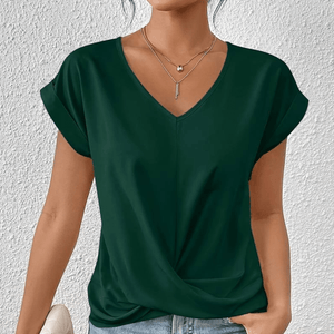 Dunkelgrünes V-Ausschnitt-Top mit Twist-Detail, getragen von einer Frau | Fashion Peak